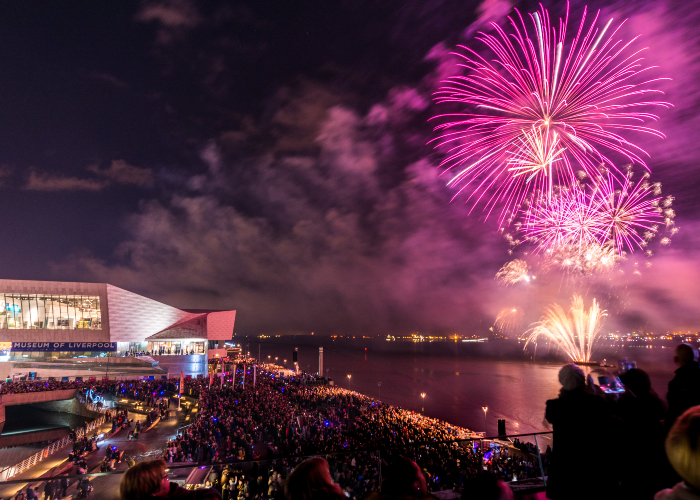 fireworks in the sky over the River Mersey as thousands look on from the Pier Head