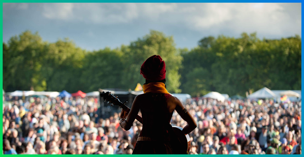 Lady performing on stage in front of a large crowd at Africa Oye in Sefton Park