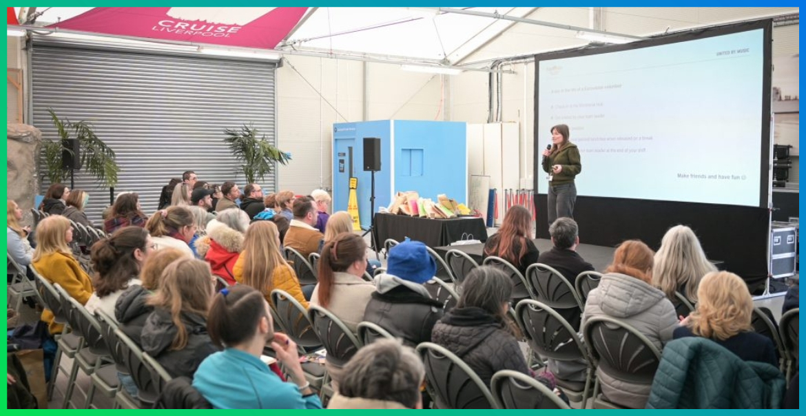 A group of volunteers sit and watch a presentation for Eurovision Volunteering training.