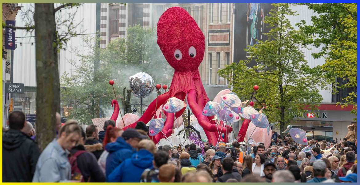 A giant octopush inflatable puppet being walked through Liverpool's highsteet during The Blue and Yellow Submarine Parade as part of EuroFestival.