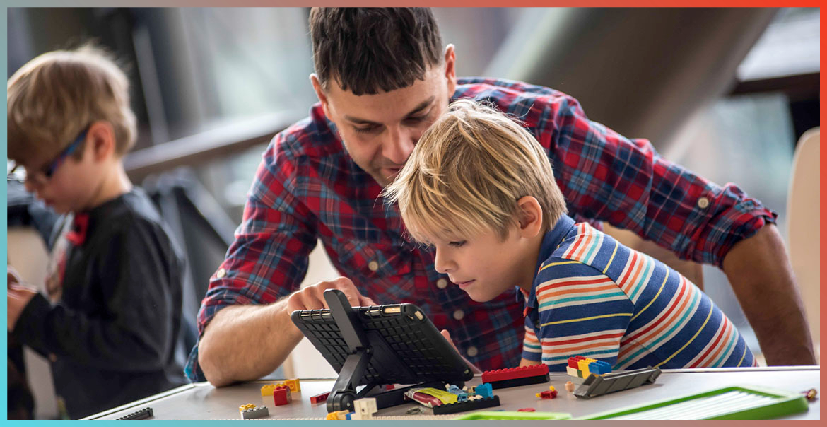 A man and child working on an touch screen tablet.