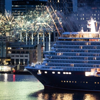 Queen Anne ship leaving Livepool at night with the iconic waterfront and fireworks in the background.