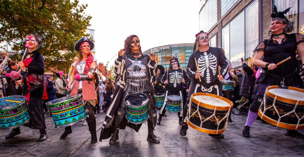 A street performances of drummers dressed as Halloween characters, playing the drums