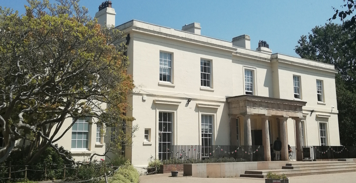 An exterior view of Calderstones Mansion House on a sunny day