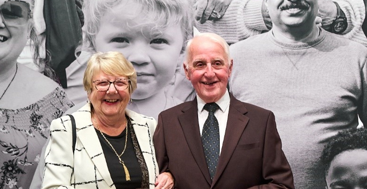 A man and woman stood in front of a large photographic display