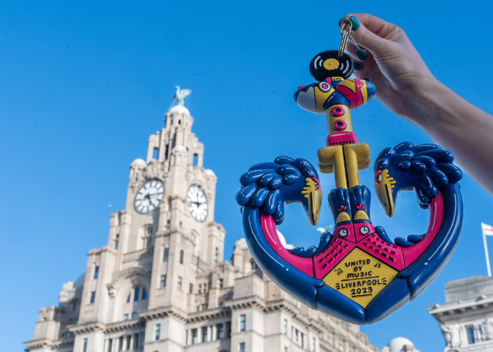 image of Liverpool's Eurovision key being held in the air with the Royal Liver Building in the background on a sunny day