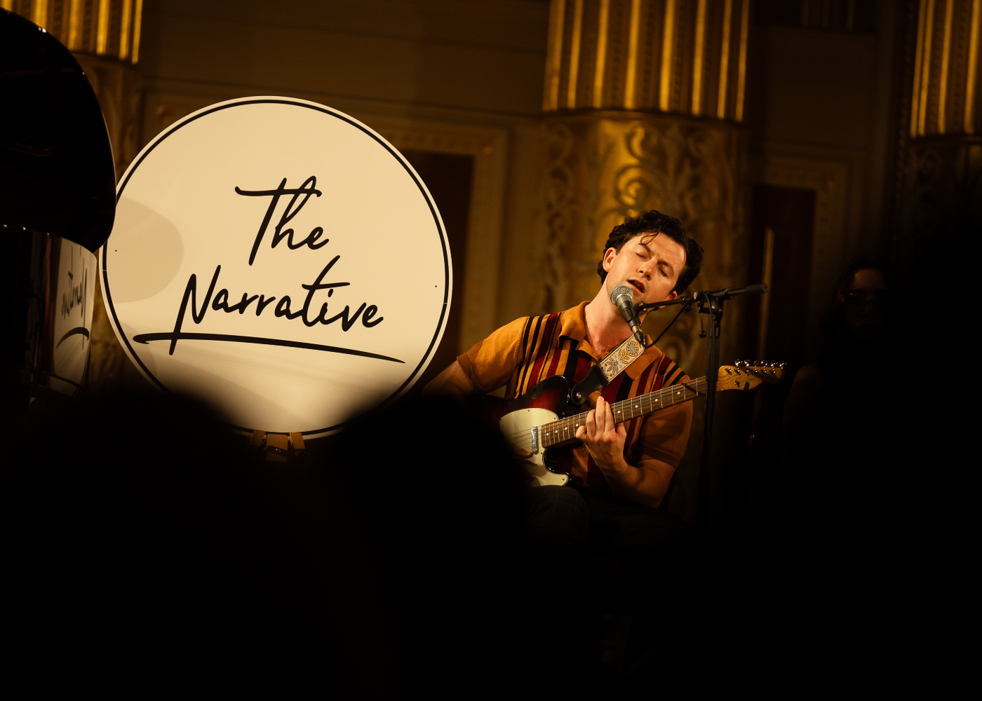 Singer song writer MT Jones performing in St George's Hall Concert Room with a sign showing the words The Narrative