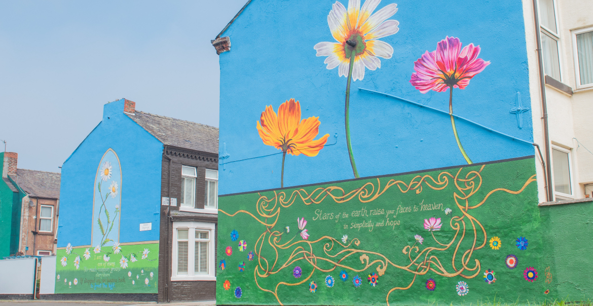 An image of streets with a mural on each of the gable ends of terraced houses