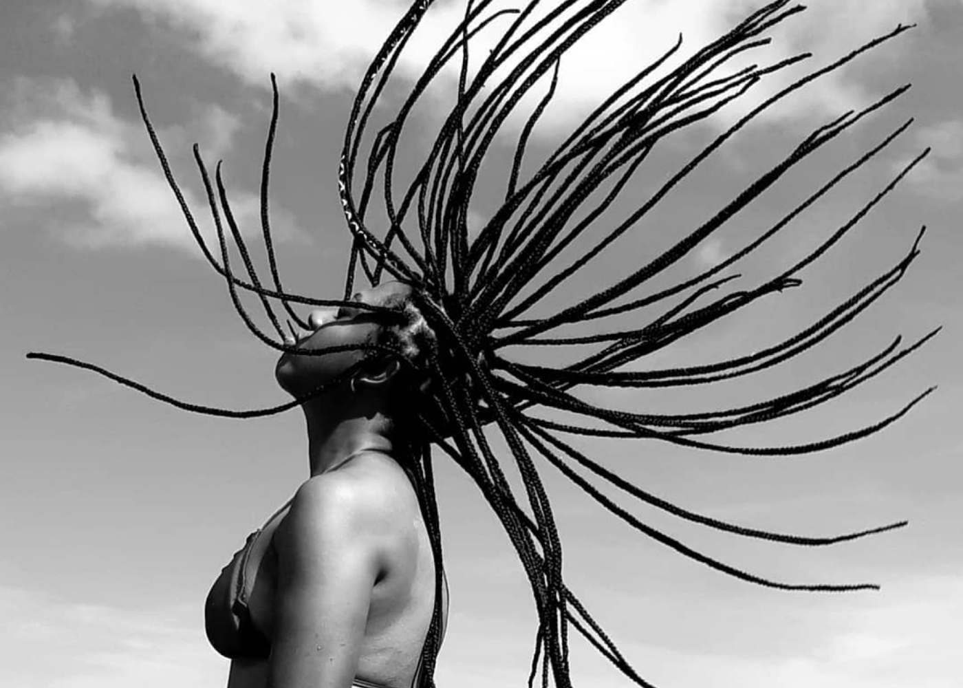 picture of a black woman with dreadlocks swished into the air