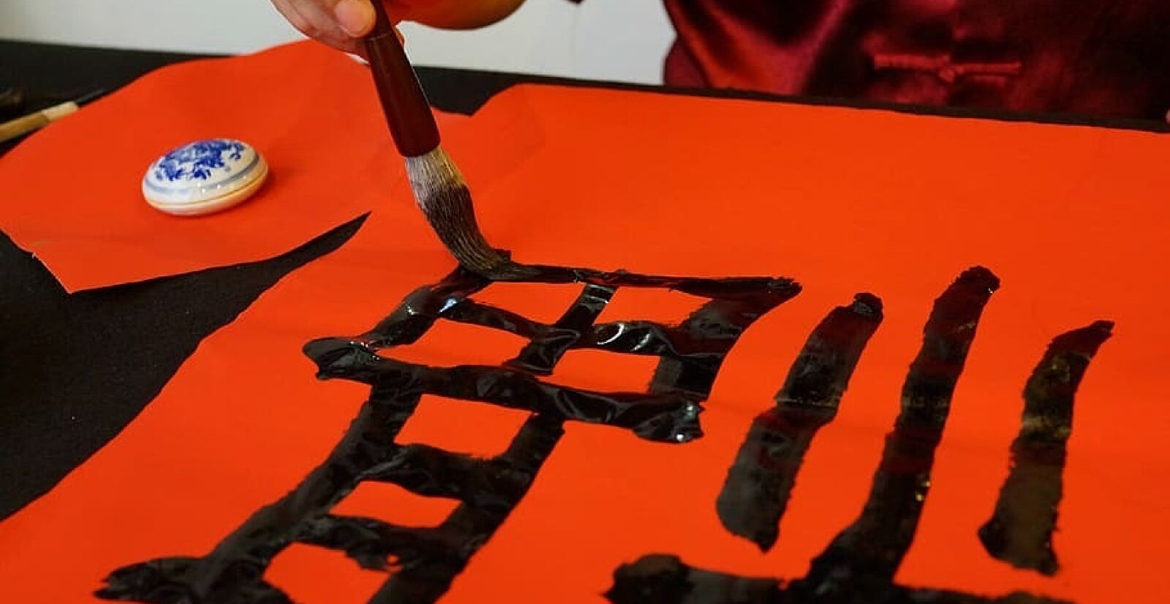 A close-up image of someone paintng caligraphy