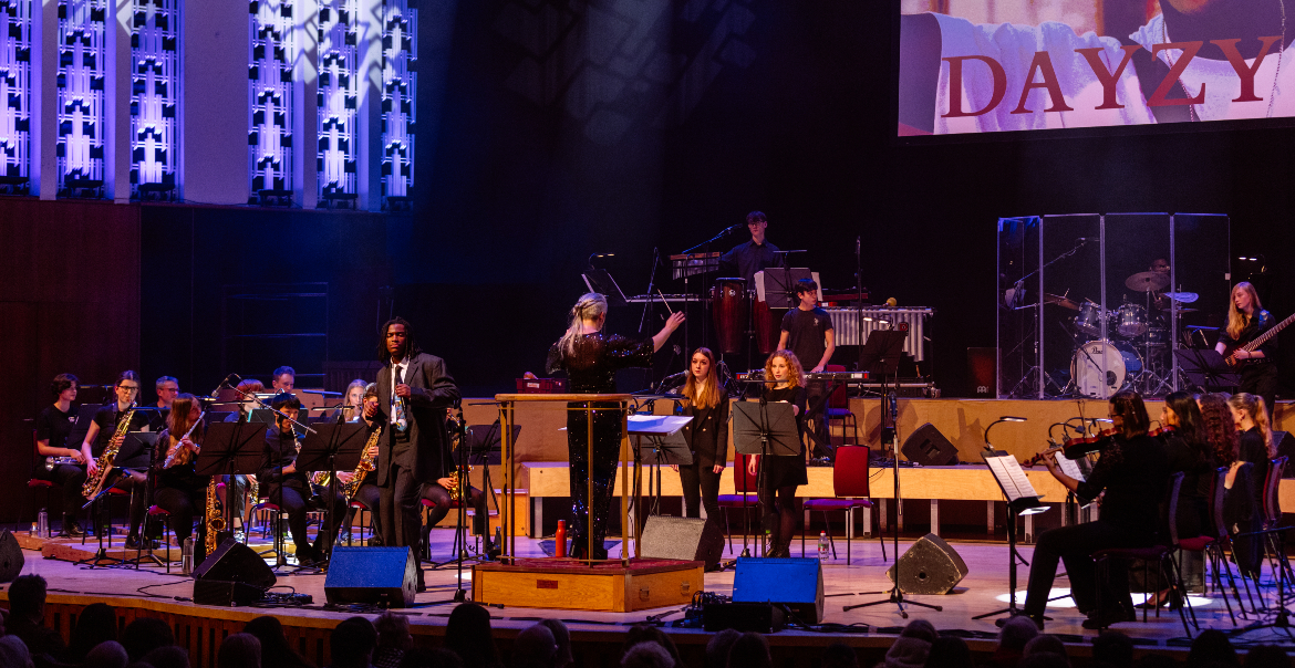 An image of a person performing on the Liverpool Philharmonic stage with an orchestra