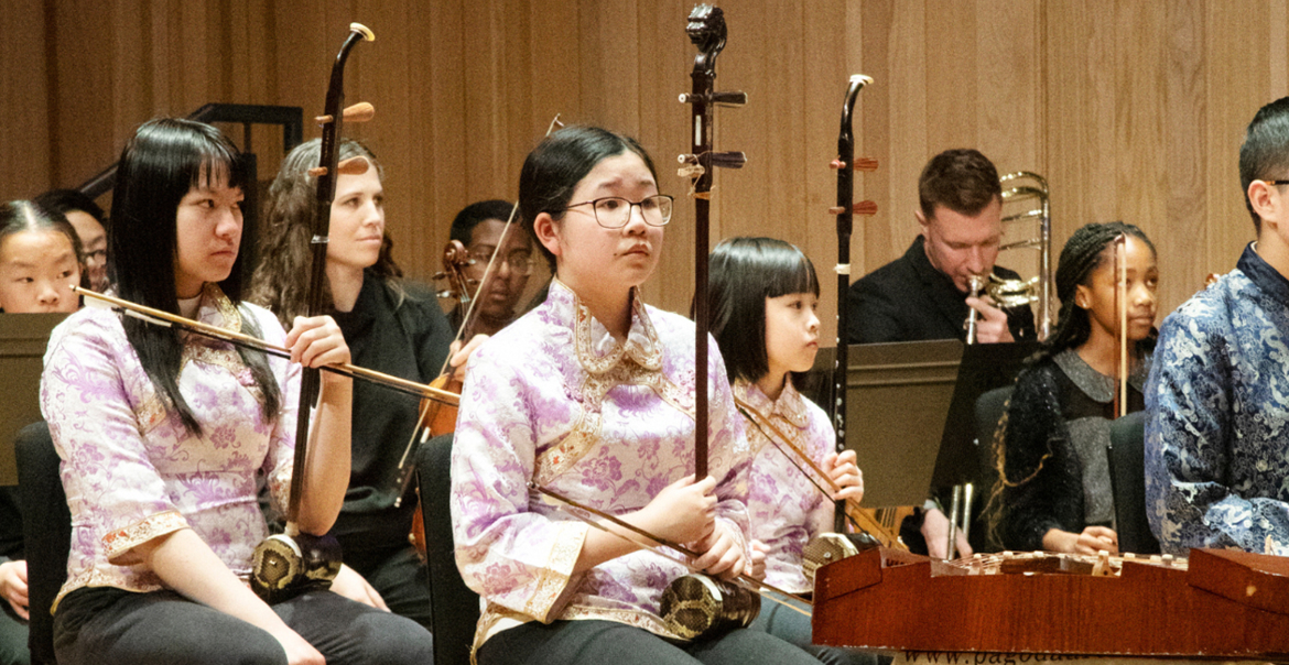 An image of an orchestra wearing traditional Chinese clothes holding their instruments