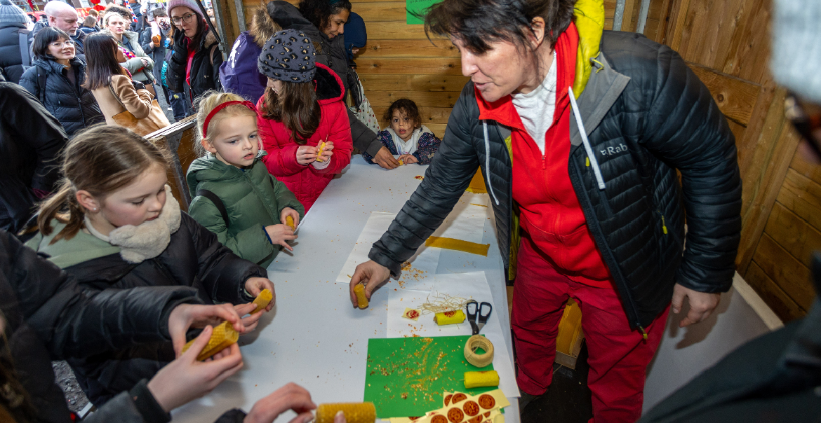 Young children engaging with a Chinese New Year traditional activity inside a wooden cabin